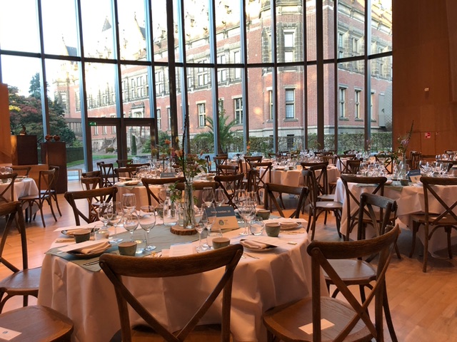 Sfeervolle dineropstelling in een lichte zaal met ronde tafels